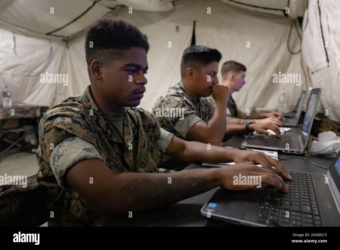 U.S. Marine Corps Lance CPL. Devin D. McDaniel, Front, Datensystemadministrator, Lance CPL. David Garcia, Mitte, und Lance CPL. Gage Kirkpatrick, Betreiber von Satellitensystemen für Heckübertragungen, die alle dem Deployable Joint Command and Control Platoon, 7. Communication Battalion, III Marine Expeditionary Force Information Group, zugewiesen sind, konfigurieren das neue Systemupdate in Camp Hansen, Okinawa, Japan, 19. Oktober 2022. DJC2 Platoon übte die Installation, Konfiguration, Fähigkeiten und Fehlerbehebungsverfahren ihrer Geräte. III MIG fungiert als Vorhut von III MEF, der I betreibt Stockfoto