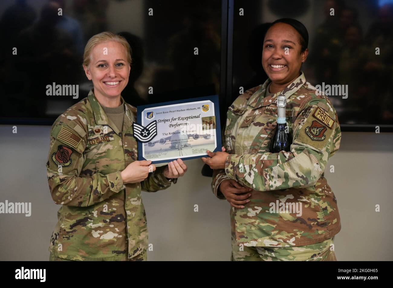 Oberst Michele Lo Bianco, Kommandeur des Flügels 15., überreicht Stabsstelle Katherine Johnson, 647. Force Support Squadron Force Management nicht beauftragter Offizier verantwortlich, mit einem Zertifikat während einer Zeremonie zur Beförderung von Streifen für außergewöhnliche Darsteller auf der Joint Base Pearl Harbor-Hickam, Hawaii, 19. Oktober 2022. STEP-Aktionen werden verwendet, um herausragende Luftmänner über den Meisterfeldwebel zu den Klassen des Stabsfeldwebel zu erkennen und zu fördern. Stockfoto