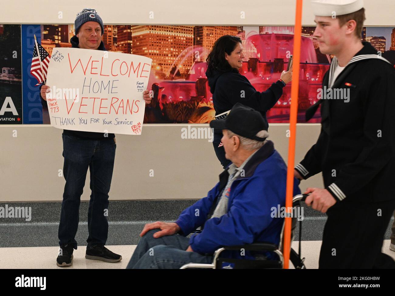 CHICAGO (Okt 19, 2022) – Seaman rekrutiert Charles Gregory, ein Beitrittssegler, der dem Surface Combat Systems Training Command Great Lakes zugewiesen wurde, begleitet einen Veteranen während des Honor Flight Chicago's 106. Fluges am Chicago Midway International Airport. Die Seestation Great Lakes und die Kommandos der Mieter brachten 154 Matrosen, um den letzten Flug von Honor Flight Chicago (HFC) im Jahr 2022 zu unterstützen. Stockfoto