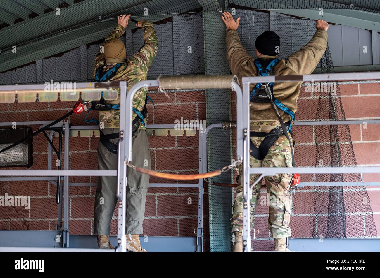 U.S. Air Force Master Sgt. Sterling Hall und Senior Master Sgt. Nate Smith, Lademeister, beauftragt mit dem Sicherheitsbüro des Luftlift-Flügels 167., befestigen Vogelnetze an der Decke einer Flüssigsauerstoffspeicherungsanlage, um Vögel davon abzuhalten, im Gebäude auf Shepherd Field, Martinsburg, West Virginia, zu brüten und zu brüten, Oktober 19, 2022. Vögel können Gefahren für den Luftverkehr darstellen und ihr Kot kann Probleme mit Sicherheit und Hygiene verursachen. Stockfoto