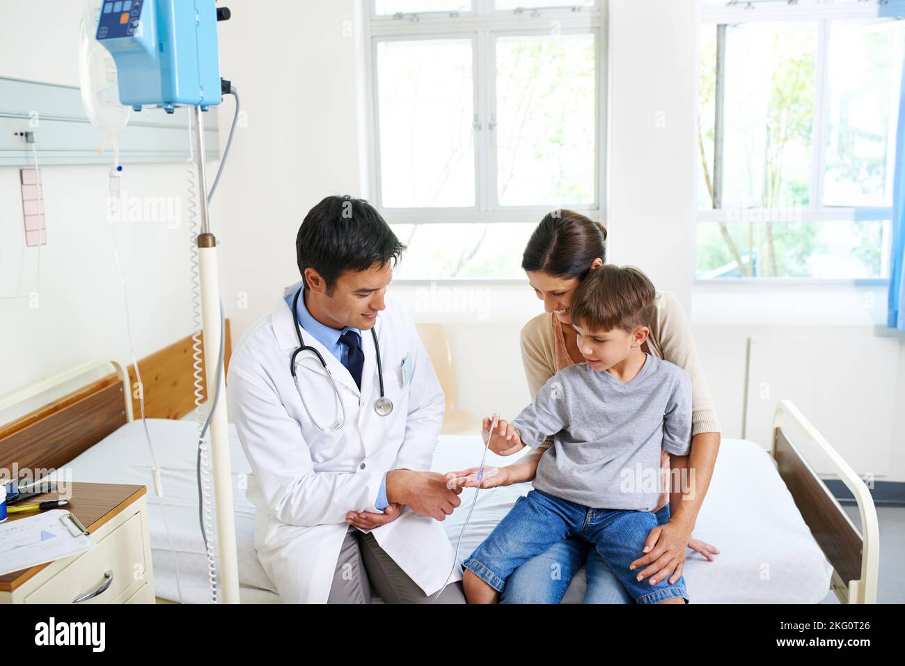 Interessiert an Medizintechnik. Ein mutiger junger Junge beobachtet seine IV mit Staunen. Stockfoto