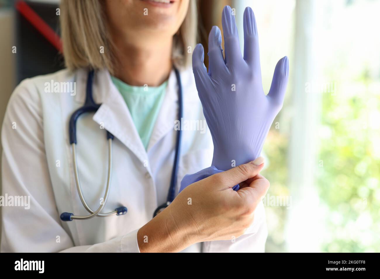 Arzt in einem medizinischen Kleid und mit Handschuhen im Klinikbüro Stockfoto