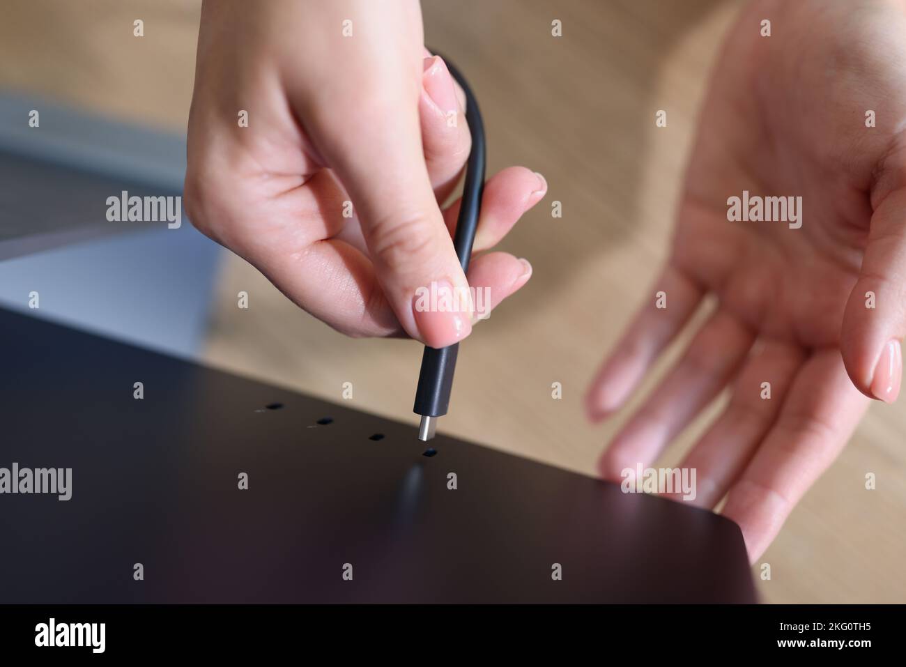 Frau händen Laptop-Bildschirm mit Kabel verbinden Stockfoto