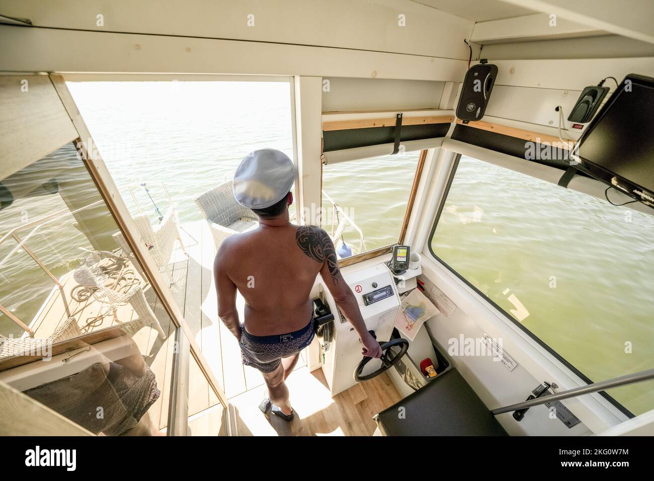 Ein männlicher Seemann, der an einem Boot am Chester Lake, Großbritannien, an Steuerrädern festhält Stockfoto