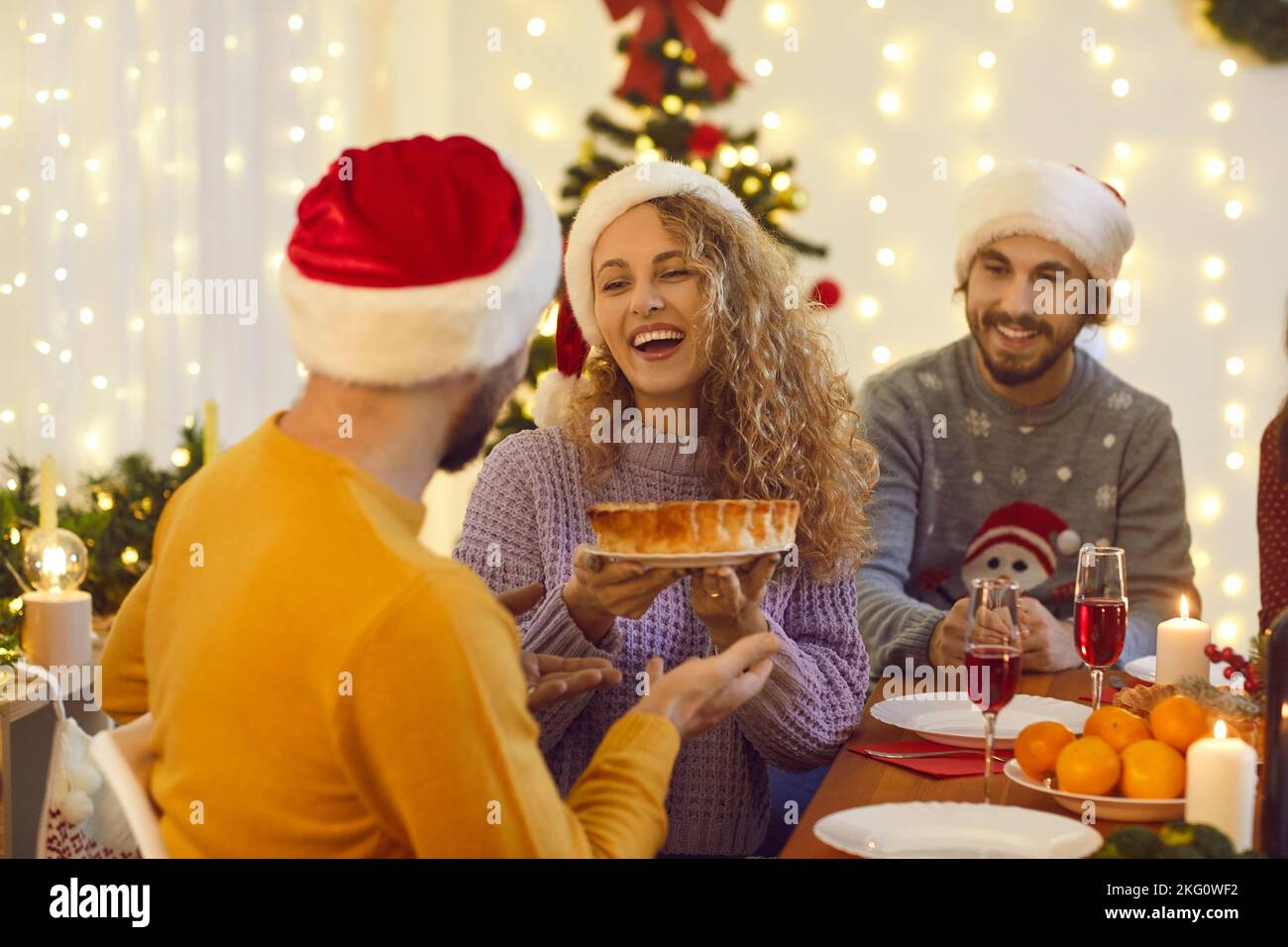 Glückliche junge Freunde, die Spaß haben und Essen auf ihrer Weihnachtsfeier zu Hause genießen Stockfoto