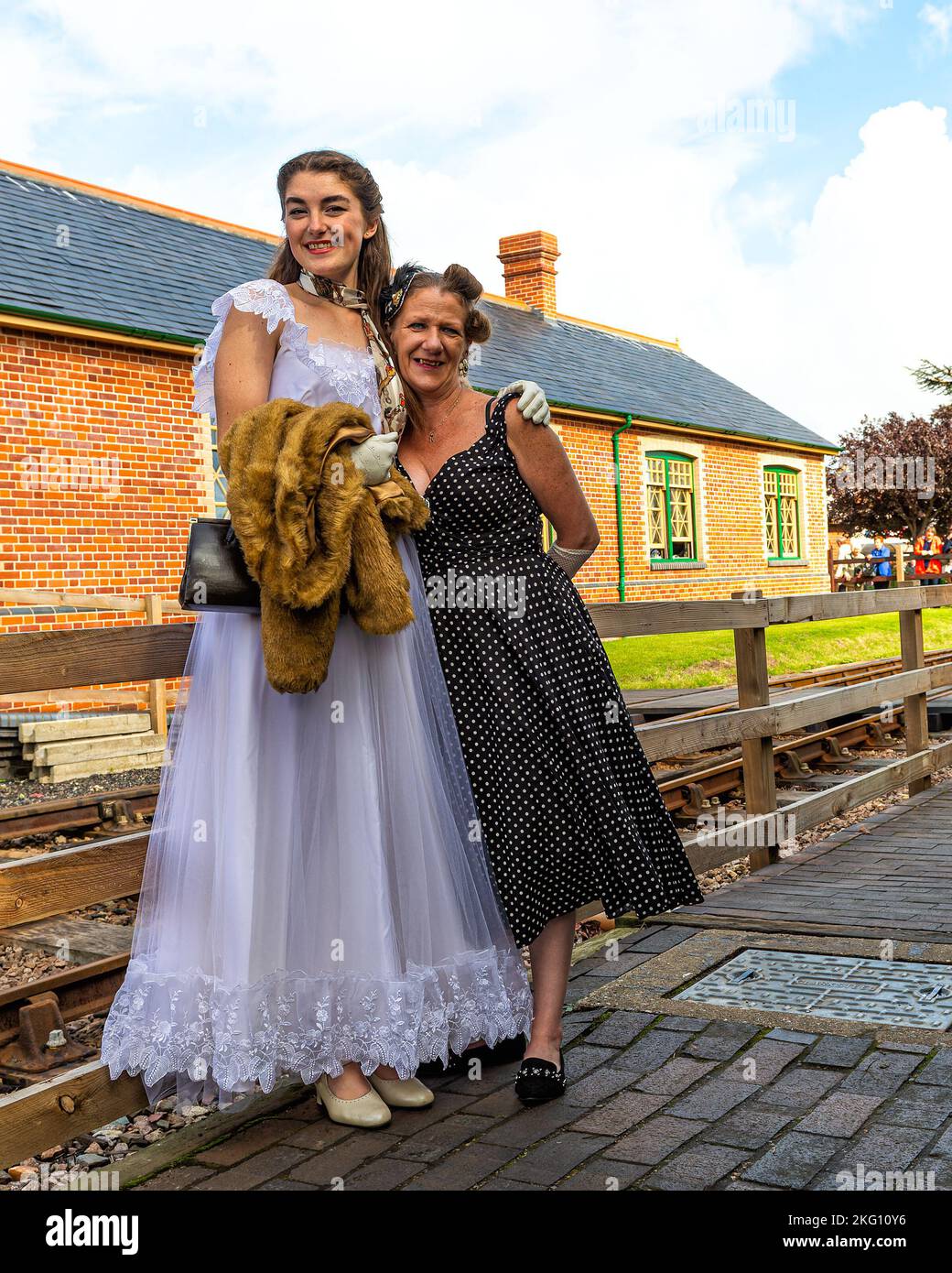 Ein paar Damen in historischen Kostümen zur Feier des 40er-Jahre-Wochenendes, das in der North Norfolk Railway, Sheringham, Norfolk, großbritannien, stattfindet Stockfoto