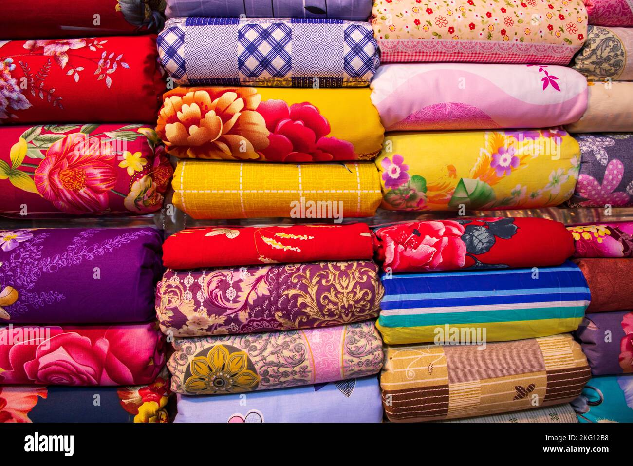 Künstlerische Vielfalt Farbton Farben Bettwäsche gestapelt im Einzelhandel Shop Regal zu verkaufen Stockfoto