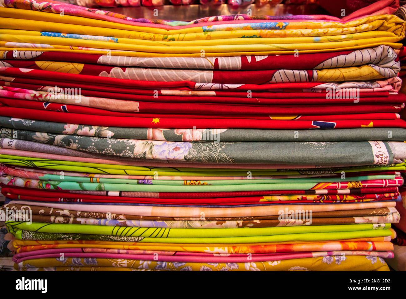 Künstlerische Vielfalt Farbton Farben Bettwäsche gestapelt im Einzelhandel Shop Regal zu verkaufen Stockfoto