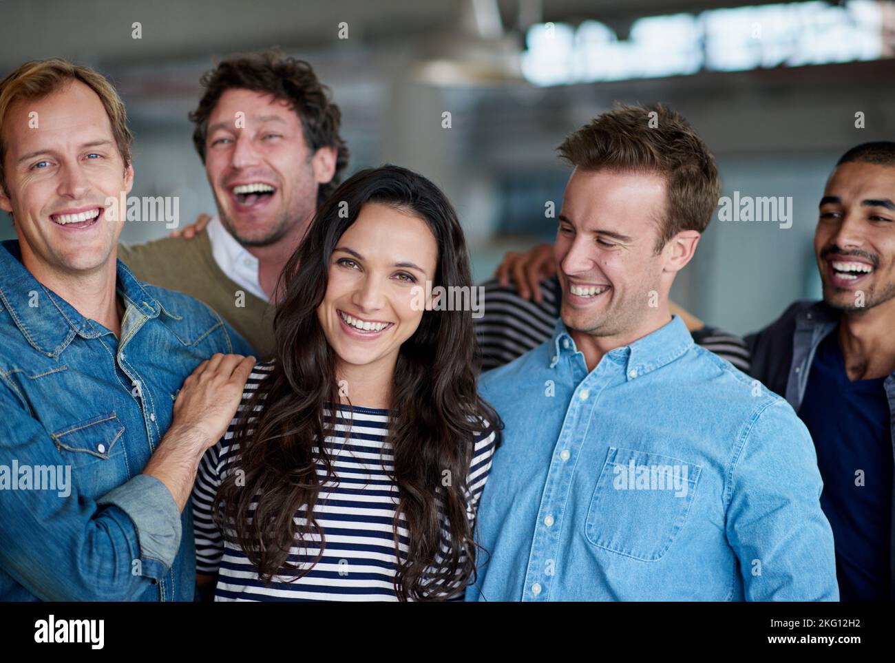 Freundliches und unterstützendes Personal. Eine lächelnde Gruppe von Mitarbeitern, die in einem Büro stehen. Stockfoto