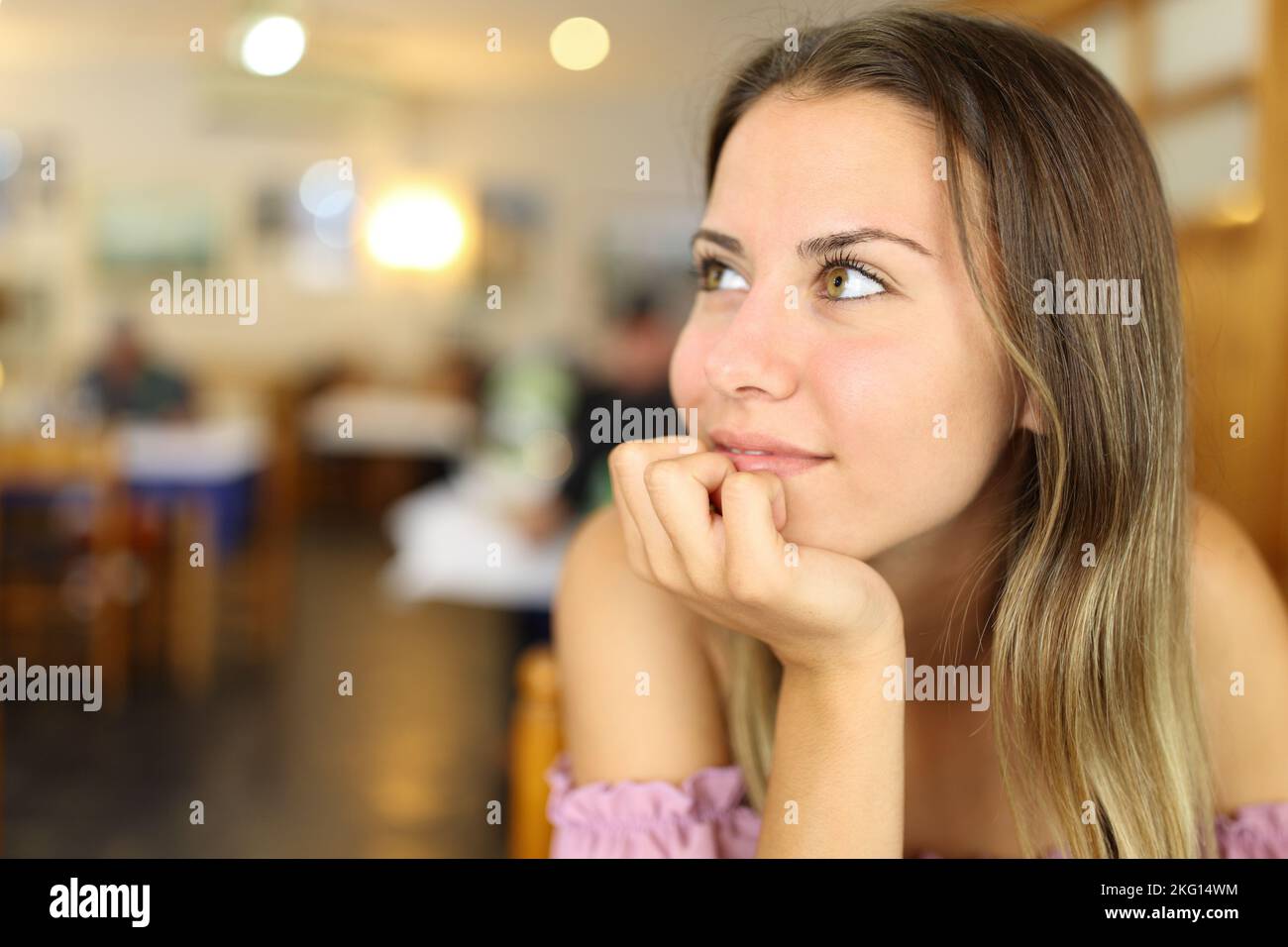 Porträt eines glücklichen Teenagers, der in einem Restaurant zur Seite schaut Stockfoto