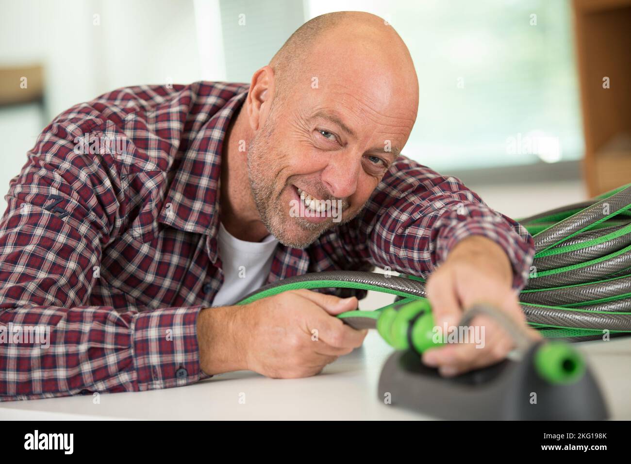 Ein Handwerker, der Gartenschlauch verbindet Stockfoto