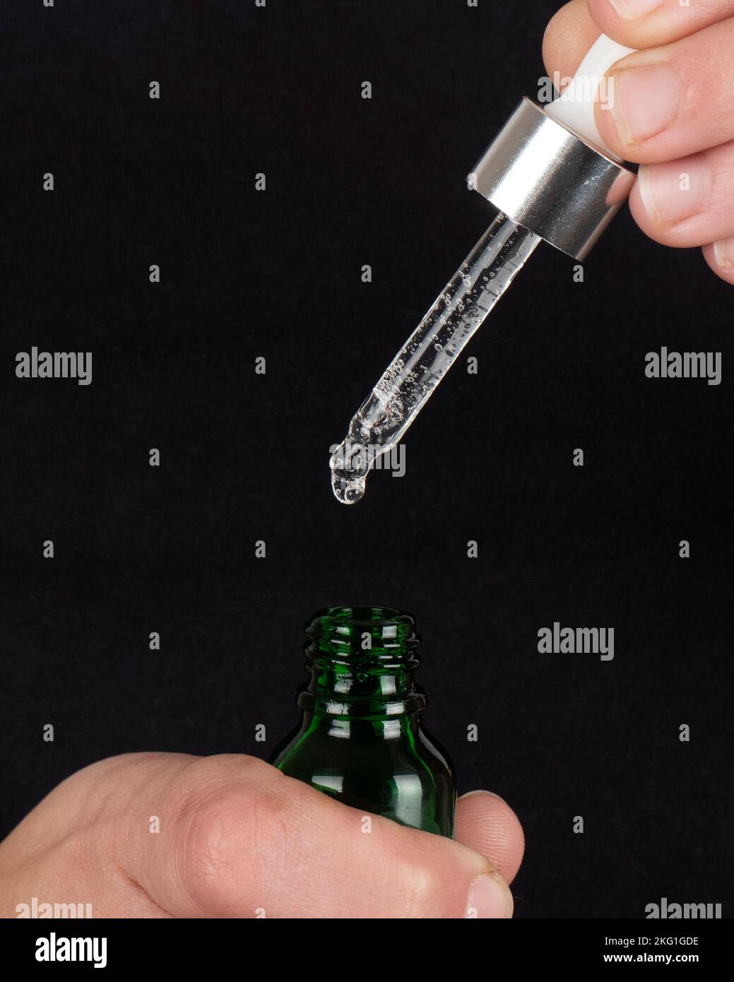 Pipette mit Flasche mit Kopierbereich, ätherisches Öl auf dunklem Hintergrund entspannen. Stockfoto
