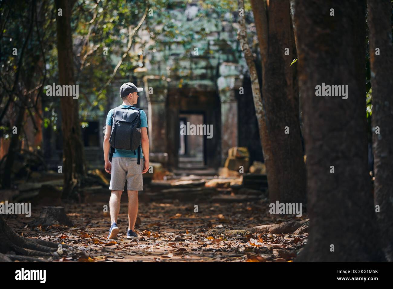 Rückansicht eines Mannes mit Rucksack, der zum alten Tempel kam. Reisende in Kambodscha. Stockfoto
