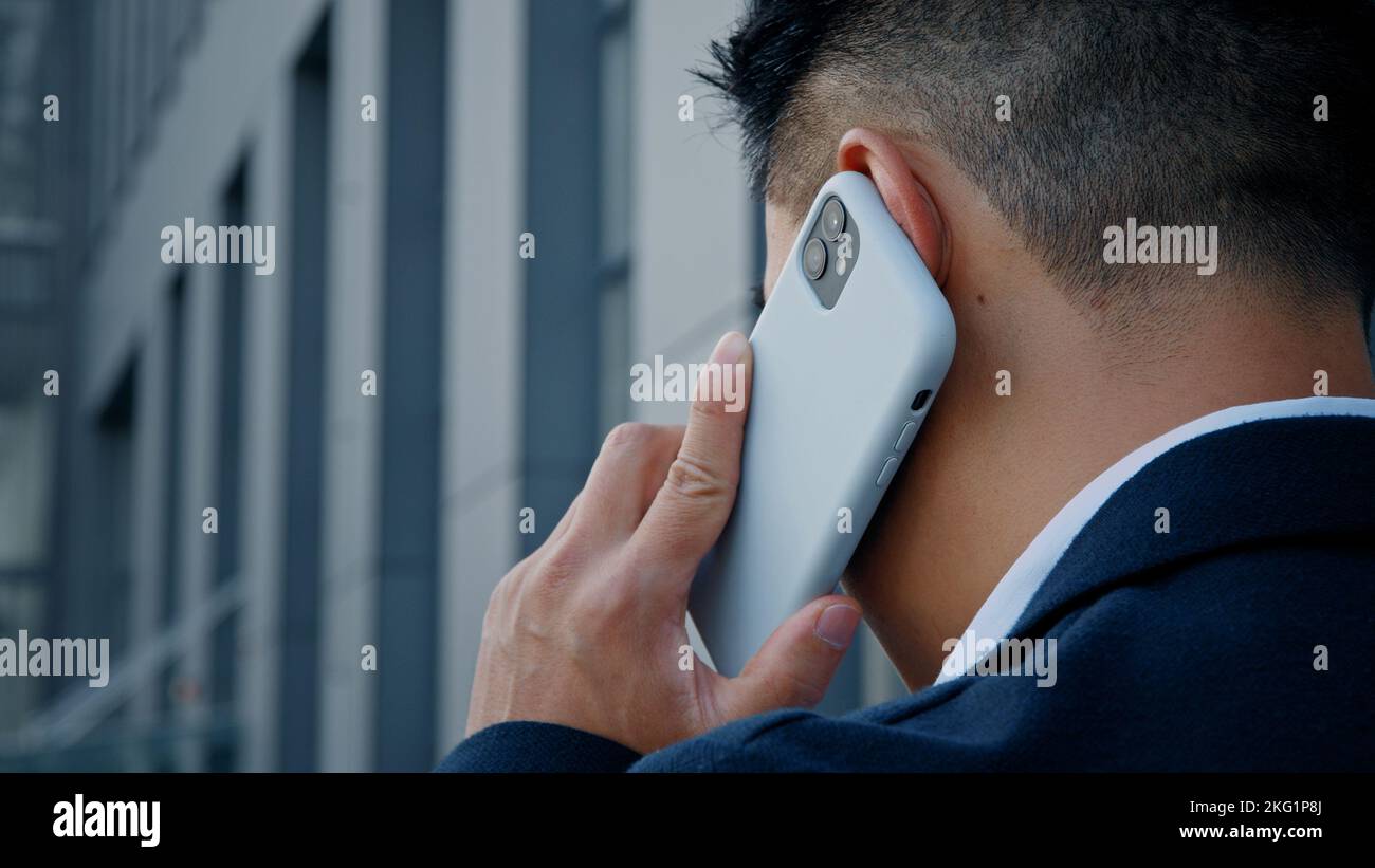 Rückansicht von hinten unkenntlich Mann in formellen Anzug Geschäftsmann Führer Verkäufer sprechen Handy im Freien in der Stadt entfernt entfernten virtuellen Gespräch Stockfoto