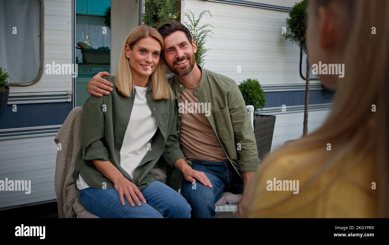 Umarmen Eltern Mutter und Vater hören unkenntlich Kind Mädchen Kind Tochter erzählen Gedicht singen Lied stehen zurück Baby reden sprechen Stockfoto