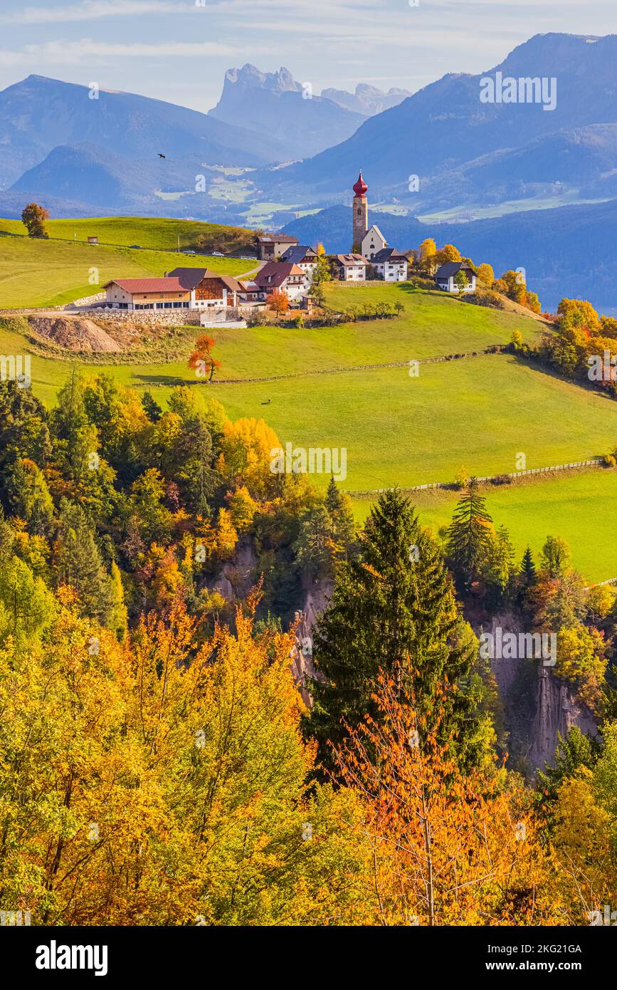 Herbst mit Herbstfarben in den Dolomiten, in Südtirol, mit Blick auf das Dorf Mittelberg mit der Nikolaikirche. Mittelberg liegt Stockfoto