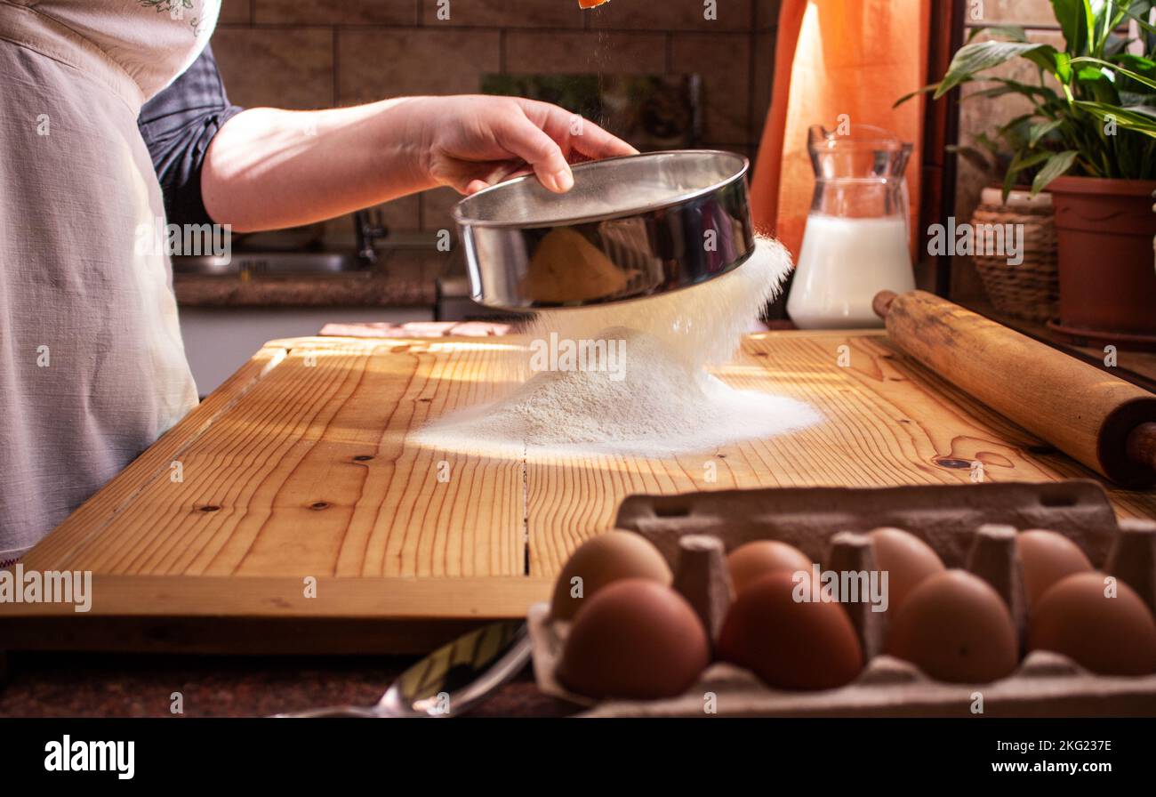 Eine Nahaufnahme einer Frau, die in einer Küche selbstgebackenes Brot zubereitet Stockfoto