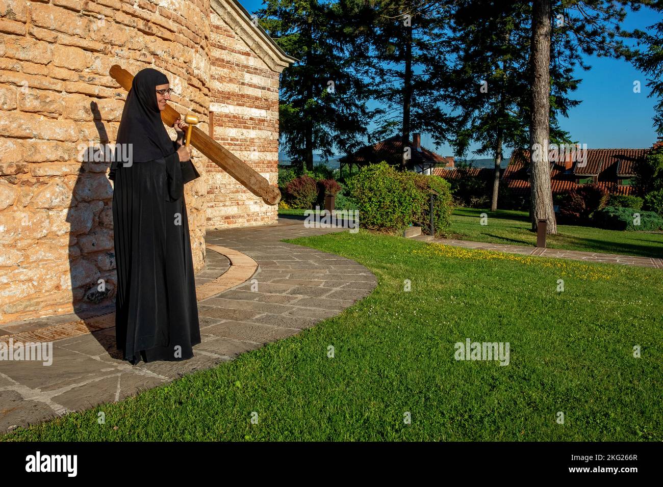Orthodoxes Kloster Zica in der Nähe von Kraljevo, Serbien. Nonne ruft zu einer Morgenfeier Stockfoto