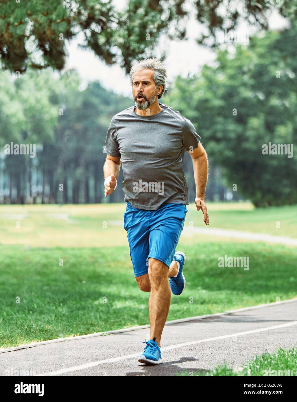 Senior Fitness Mann aktiv Sport Übung Laufen Joggen gesund Läufer fit Jogger Workout Sportler Training Marathon Geschwindigkeit Ältere gary Haare Stockfoto