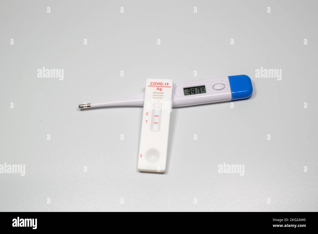 Positiver Test auf Coronavirus-Symptome des Virus auf der Temperatur des Thermometers mit COVID Stockfoto