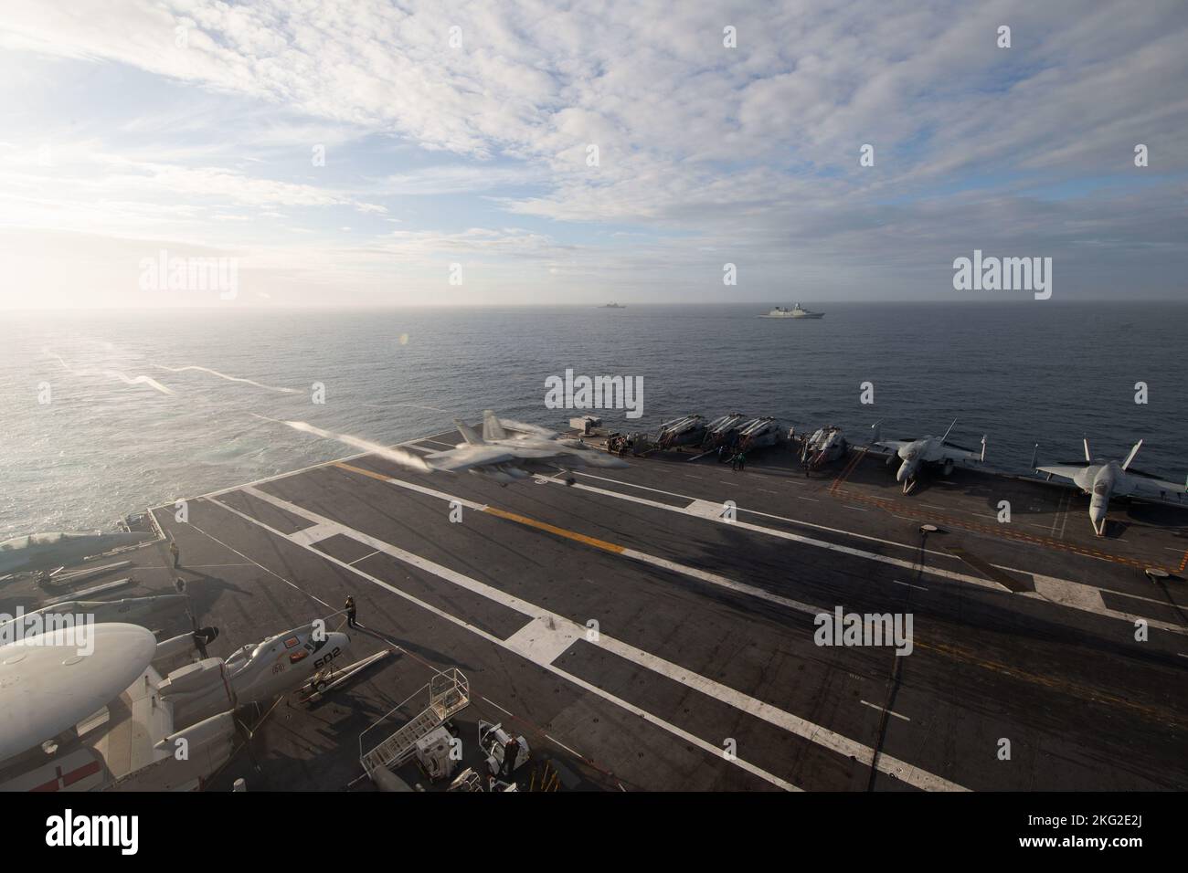 Ein F/A-18E Super Hornet, das an die 'Tomcatters' des Strike Fighter Squadron (VFA) 31 befestigt ist, landet auf dem Flugdeck des erstklassigen Flugzeugträgers USS Gerald R. Ford (CVN 78), während das Schiff in Formation mit der dänischen Fregatte HDMS Peter Willemoes (F362) dampft, Und die niederländische Fregatte HNLMS De Zeven Provincien (F 802), 25. Oktober 2022. Die Gerald R. Ford Carrier Strike Group (GRFCSG) wird im Atlantischen Ozean eingesetzt und führt zusammen mit NATO-Alliierten und Partnern Trainings und Operationen durch, um die Integration für zukünftige Einsätze zu verbessern und das Engagement der US-Marine für ein friedliches, stabiles und zu demonstrieren Stockfoto