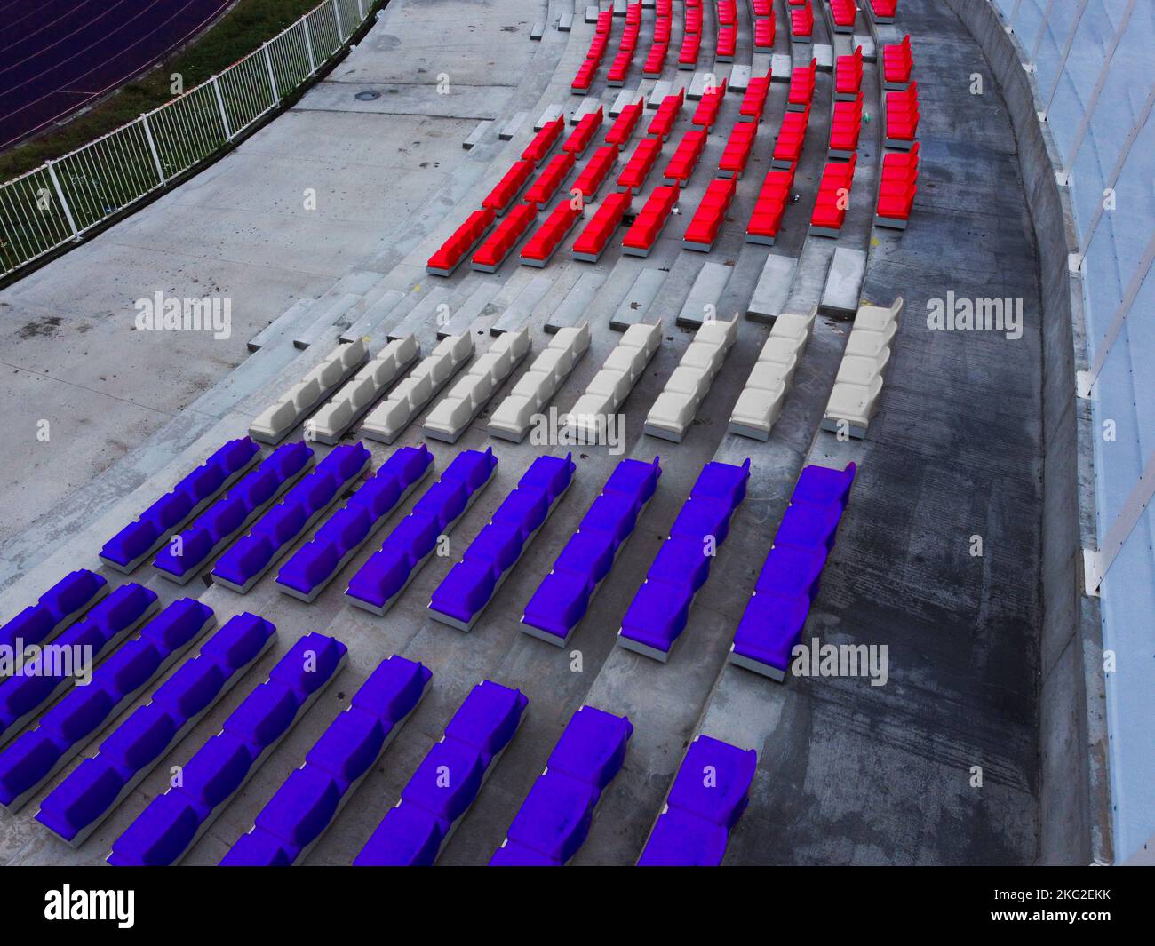 Sitze eines Fußballstadions in verschiedenen Teamfarben Stockfoto