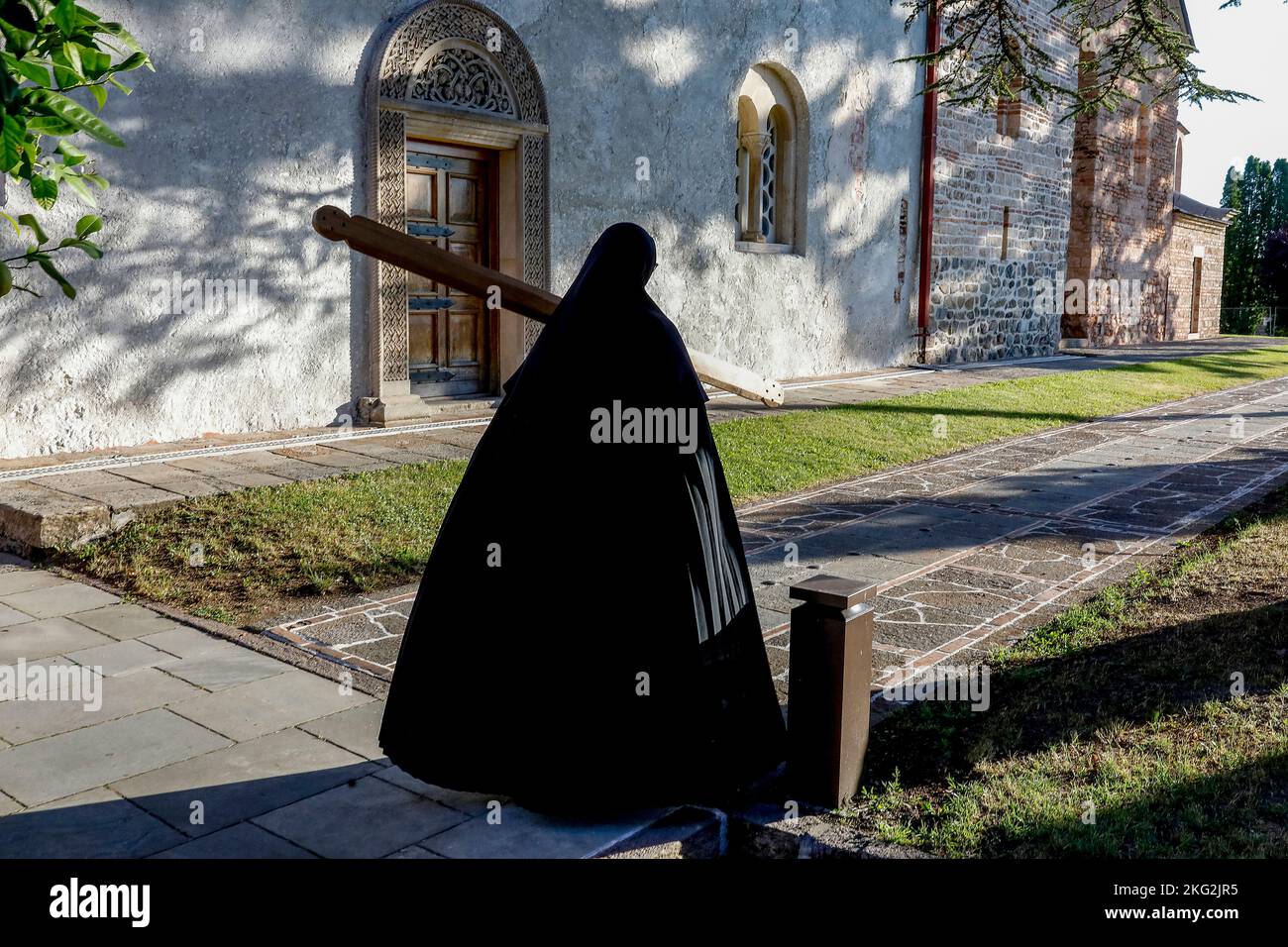 Orthodoxes Kloster Zica in der Nähe von Kraljevo, Serbien. Nonne ruft zu einer Morgenfeier, während sie durch die Kirche geht Stockfoto