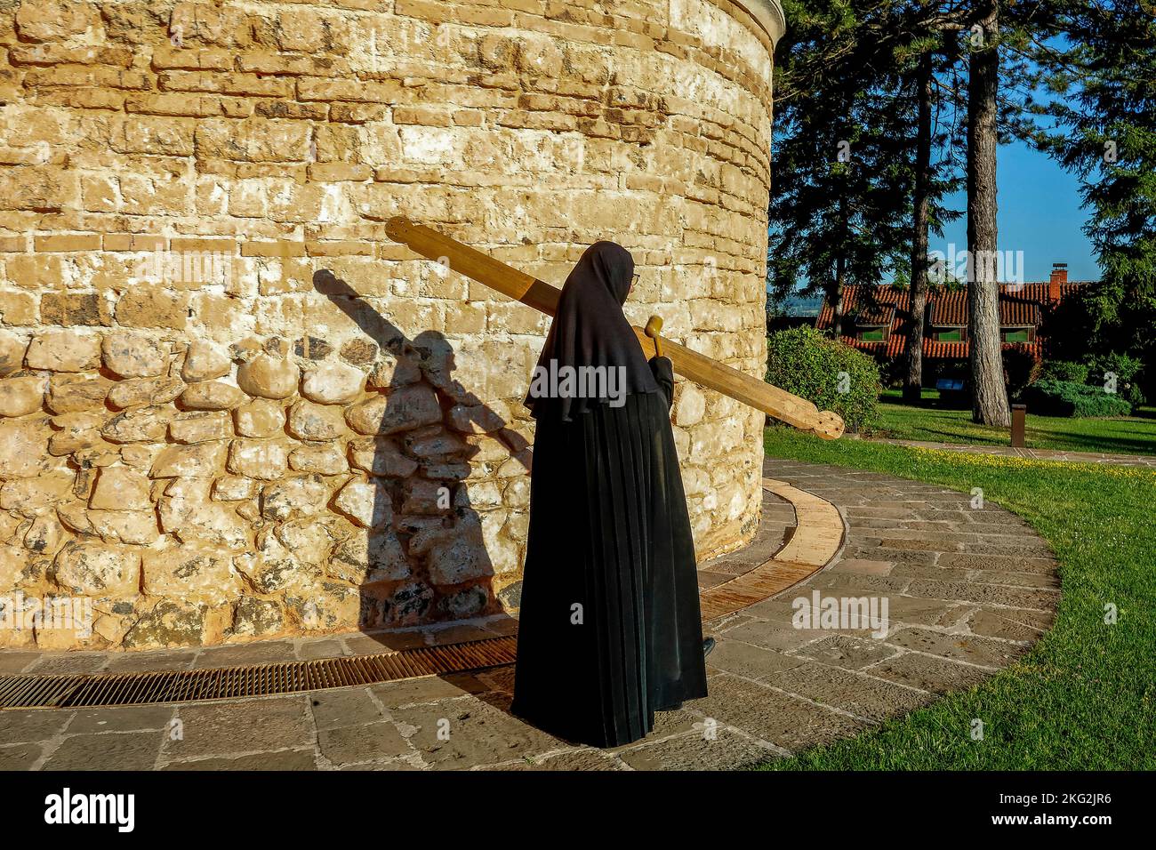 Orthodoxes Kloster Zica in der Nähe von Kraljevo, Serbien. Nonne ruft zu einer Morgenfeier, während sie durch die Kirche geht Stockfoto