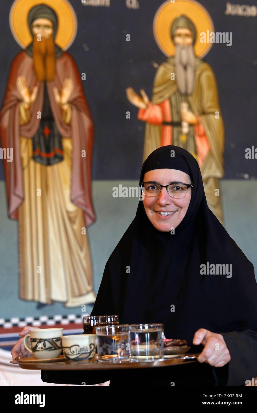 Nonne, die einem Besucher Kaffee, Raki und Gebäck im orthodoxen Kloster Zica in der Nähe von Kraljevo, Serbien, anbietet Stockfoto