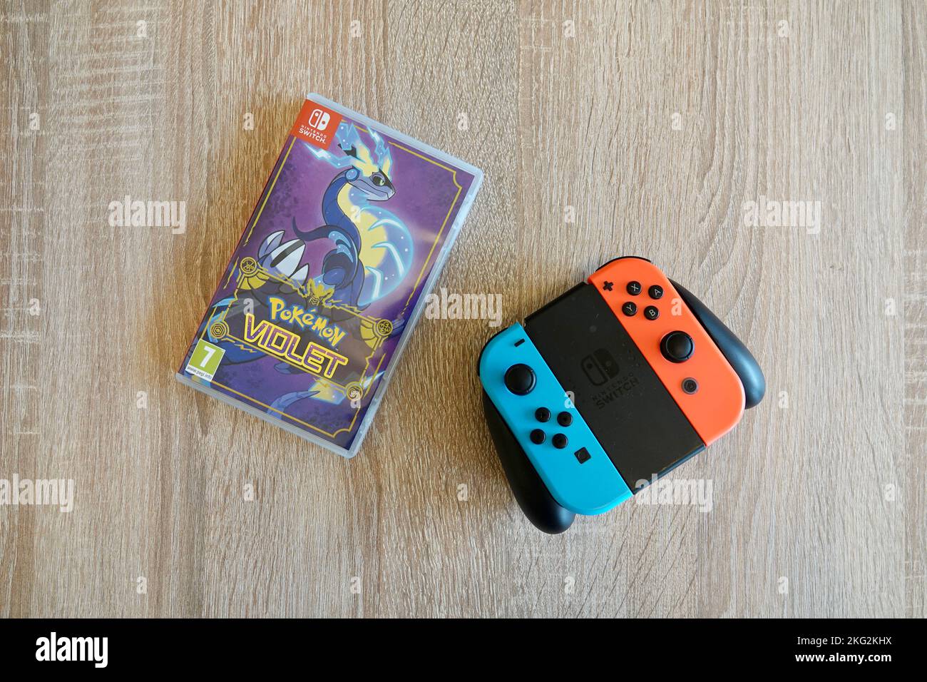 Prag, Tschechische Republik - November 18 2022: Pokemon Violet Case und Nintendo Switch Controller auf Holztisch Stockfoto