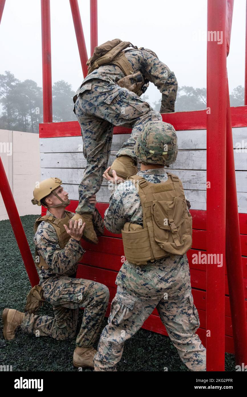 Die US-Marine und die 2. Marine Logistics Group heben sich gegenseitig über eine Barriere, während sie am Leadership Response Course auf Camp Lejeune, North Carolina, am 26. Oktober 2022 teilnehmen. Alle Hindernisse in der LRC erforderten eine große Menge an Teamarbeit und Initiative, um die Führungsfähigkeiten der Marineinfanteristen und das Vertrauen in die Führungsfähigkeiten der anderen zu stärken. Stockfoto