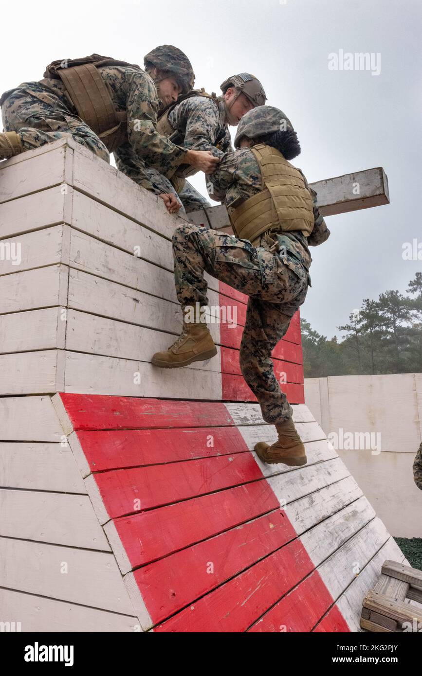 Die US-Marine und die 2. Marine Logistics Group arbeiten als Team zusammen, um während des Leadership Response Course (LRC) auf Camp Lejeune, North Carolina, am 26. Oktober 2022 ein Hindernis zu überwinden. Alle Hindernisse in der LRC erforderten eine große Menge an Teamarbeit und Initiative, um die Führungsfähigkeiten der Marineinfanteristen und das Vertrauen in die Führungsfähigkeiten der anderen zu stärken. Stockfoto