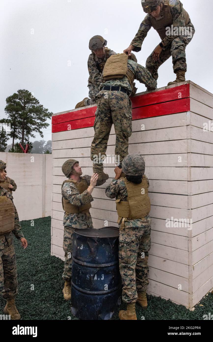 Die US-Marine und die 2. Marine Logistics Group arbeiten als Team zusammen, um während des Leadership Response Course (LRC) auf Camp Lejeune, North Carolina, am 26. Oktober 2022 ein Hindernis zu überwinden. Alle Hindernisse in der LRC erforderten eine große Menge an Teamarbeit und Initiative, um die Führungsfähigkeiten der Marineinfanteristen und das Vertrauen in die Führungsfähigkeiten der anderen zu stärken. Stockfoto