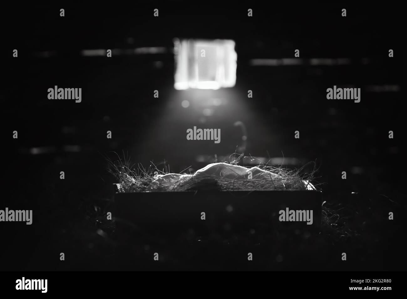 Helles Licht aus dem Fenster beleuchtet das Jesuskind in der Krippe, Weihnachten und Weihnachten im Hintergrund, um die Geburt Jesu Christi zu feiern Stockfoto