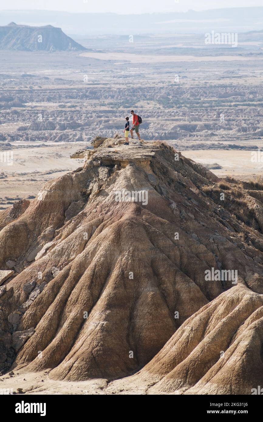 Nicht wiedererkennbare Leute, die wandern. Vater erzieht seinen Sohn in der Natur. Klettern auf den Gipfel eines Wüstenbergs. Stockfoto