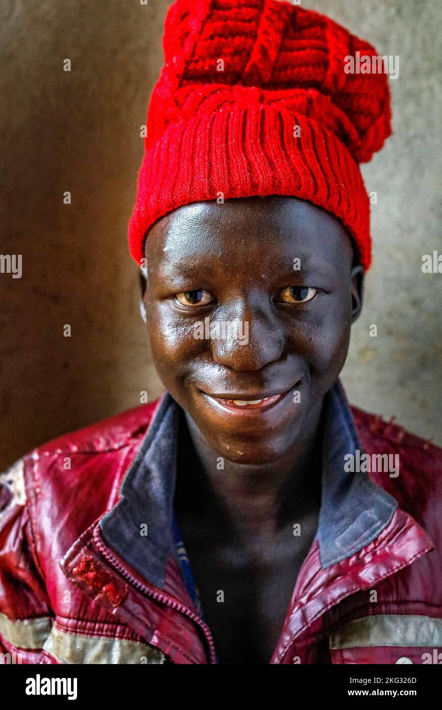 Lächelnder, behinderter Junge, der in einem Haus im Süden Ruandas sitzt Stockfoto