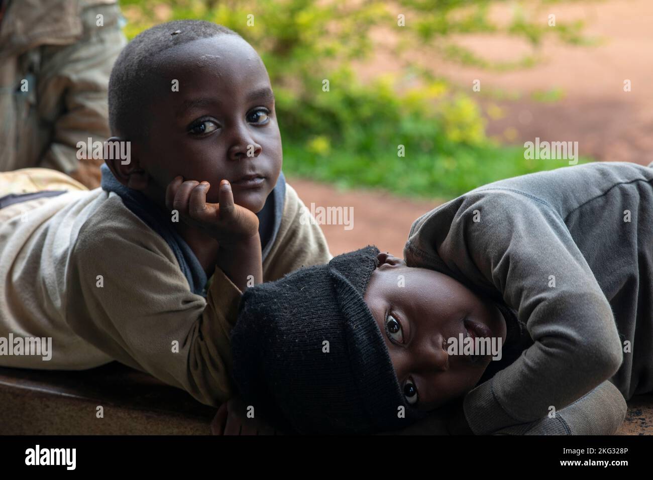 Jungen liegen an einer Wand im Süden Ruandas Stockfoto