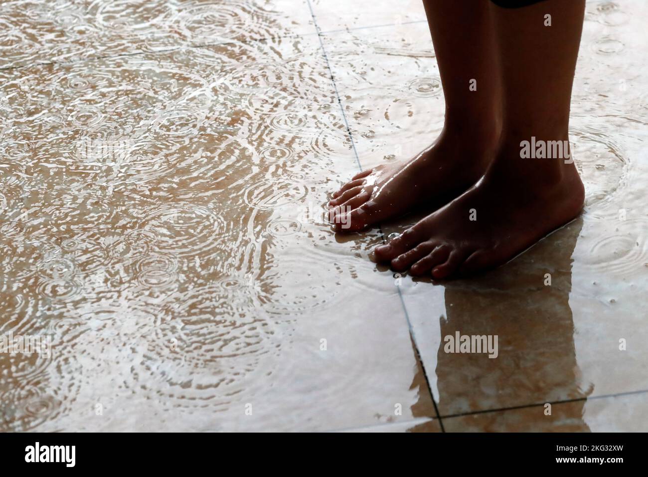 Regenzeit. Barfuß Frau im Regen. Nahaufnahme. Vietnam. Uong Bi. Vietnam. Stockfoto