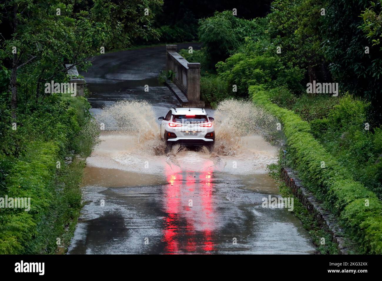 Eine 4X4-Fahrt durch einen überfluteten Straßenabschnitt während der Regenzeit. Vietnam. Uong Bi. Vietnam. Stockfoto