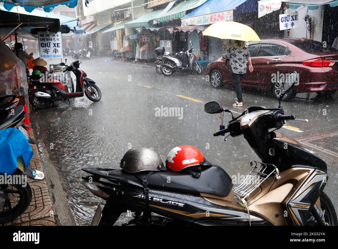 Motorrad bei starkem Regen, Wasser auf der Straße. Regenzeit in Saigon, Ho-Chi-Minh-Stadt. Vietnam. Stockfoto