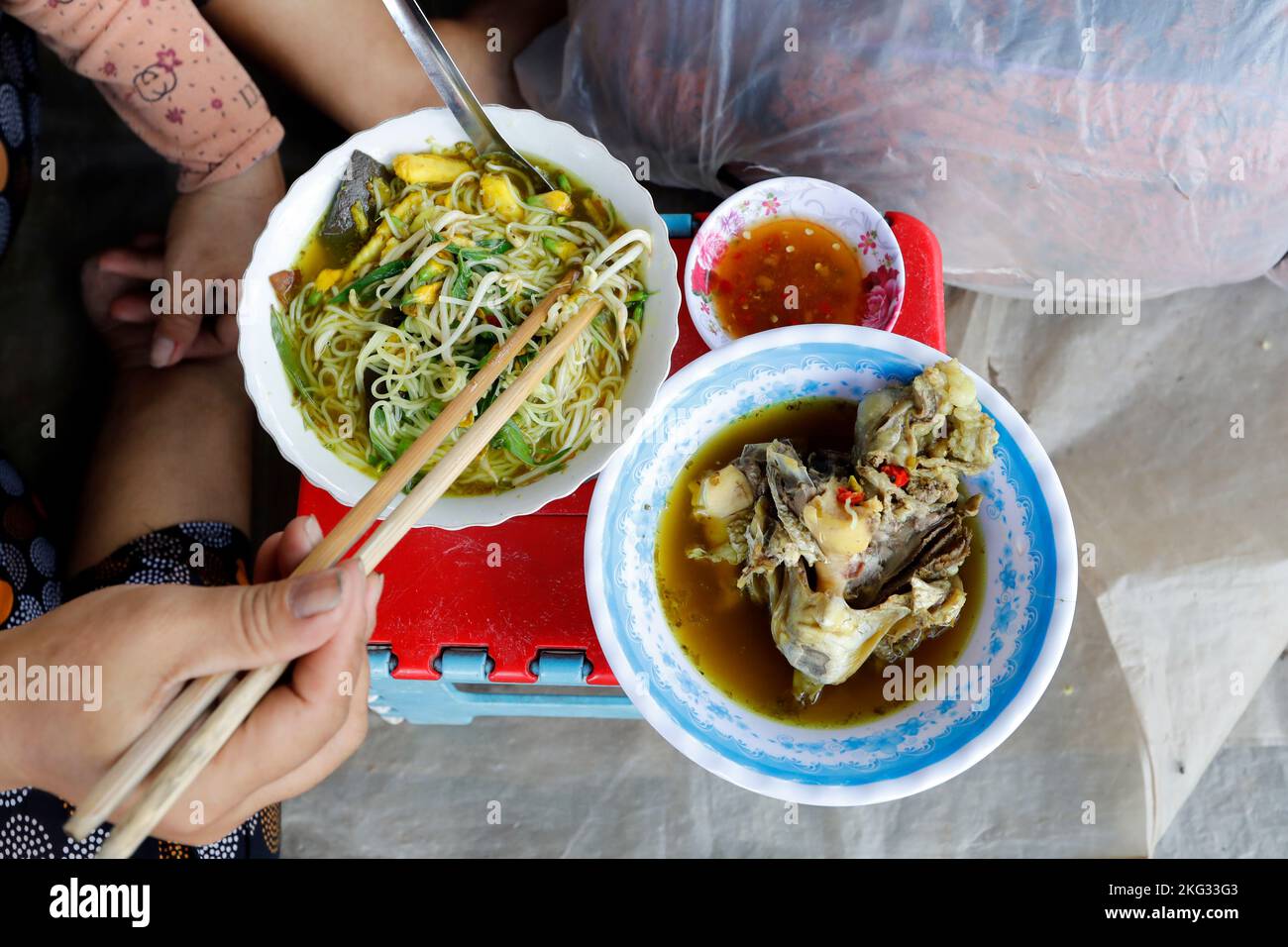 Frau essen Vietnam Nudelsuppe mit Kopf von Fisch im Straßenrestaurant. Tan Chau. Vietnam. Stockfoto