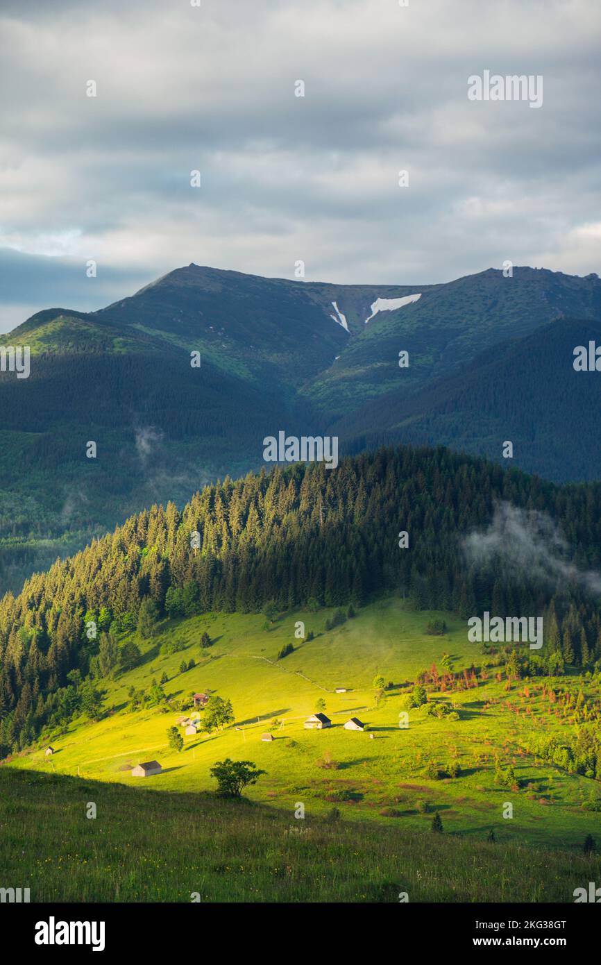 Ländliche Berglandschaft mit Sonnenlicht auf den grünen Hügeln bei Sonnenaufgang Stockfoto