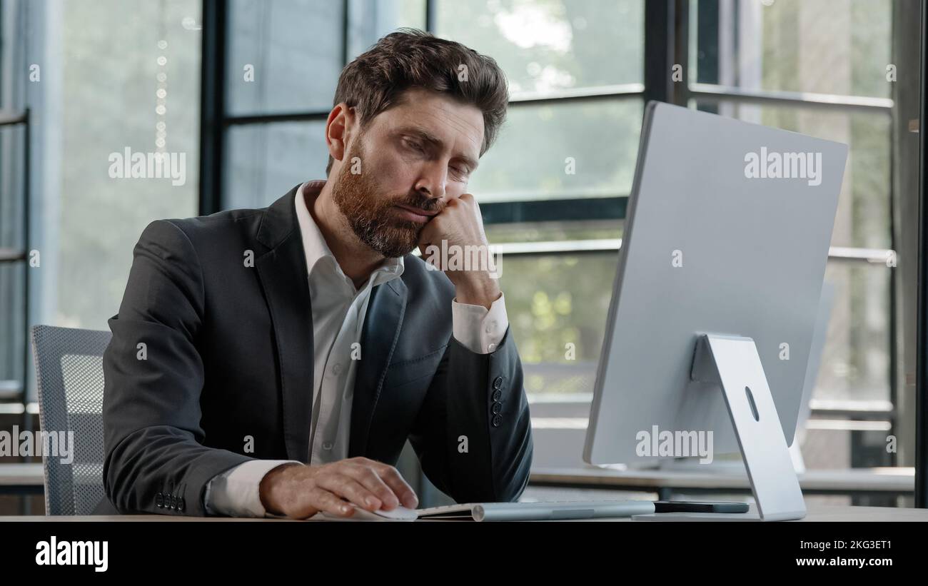 Schlafen müde faul Nappen Gähnen Erwachsenen bärtig Mann männlich Manager Arbeiter gelangweilt bei der Arbeit Projekt online im Computer im Büro kaukasischen reifen krank Stockfoto