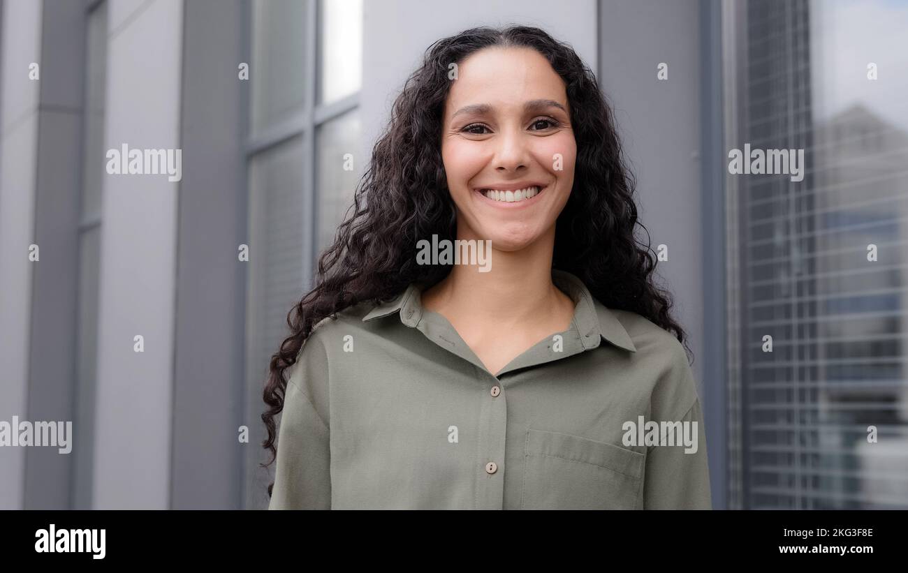 Close-up Rückansicht von hinten dunkel lockig lange Haare weibliche Frisur Frau drehen Kopf drehen Kamera glücklich lächelndes Mädchen Hispanic Latein kaukasisch Stockfoto