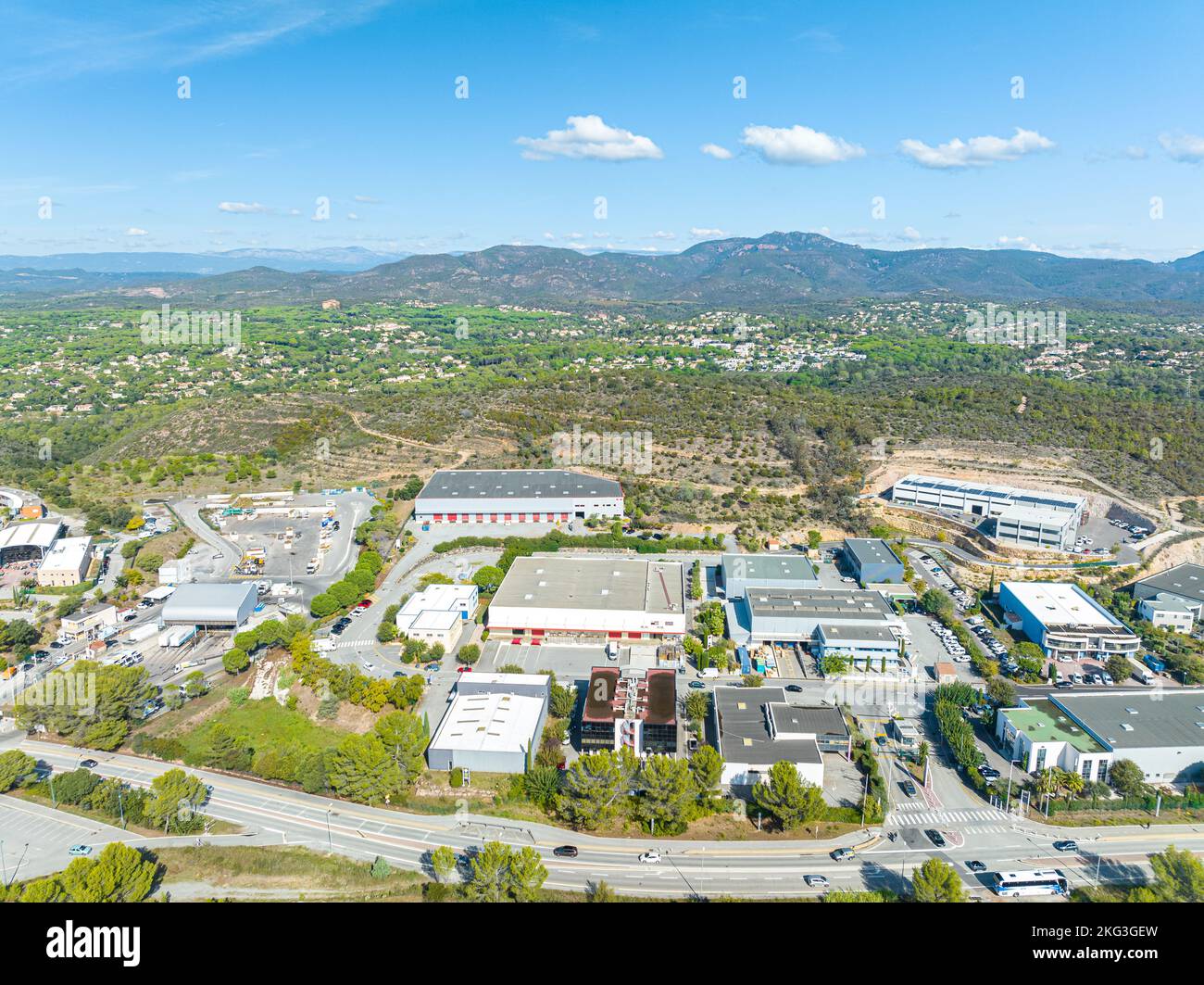 Panoramablick auf das Industriegebiet, umgeben von verschiedenen Infrastrukturen, Grünflächen und vielen in Reihen geparkten Autos im Var, Frankreich Stockfoto