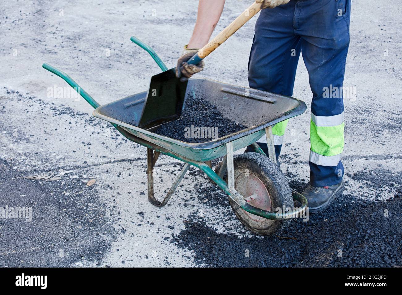 Asphalt in Schubkarre Bediener bereitet Mischung mit Uniform zu Stockfoto