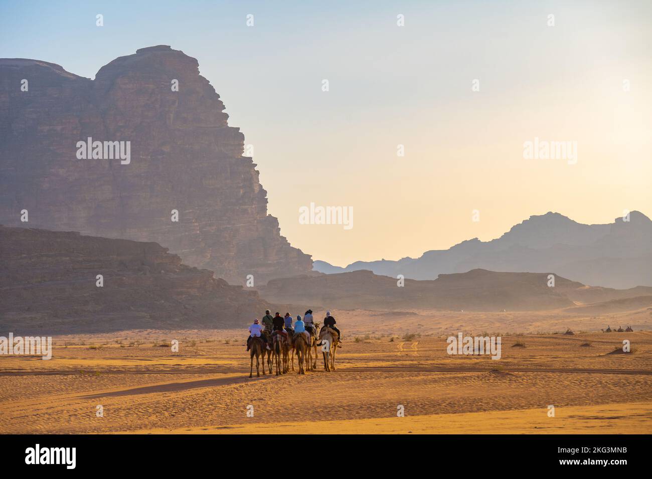 Touristen auf einem abendlichen Kamelpfad auf dem Sand des Wadi Rum Jordan Stockfoto