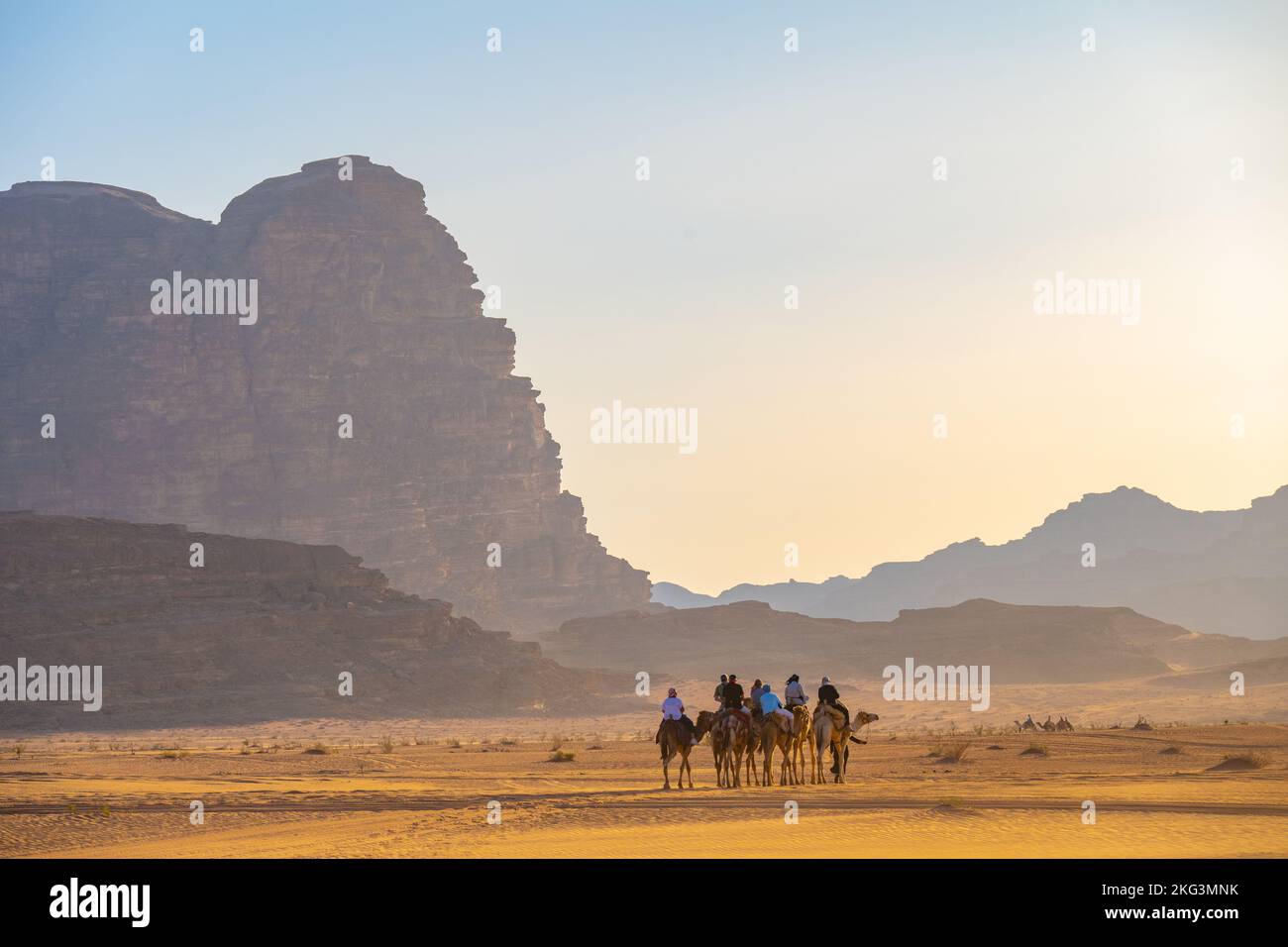 Touristen auf einem abendlichen Kamelpfad auf dem Sand des Wadi Rum Jordan Stockfoto