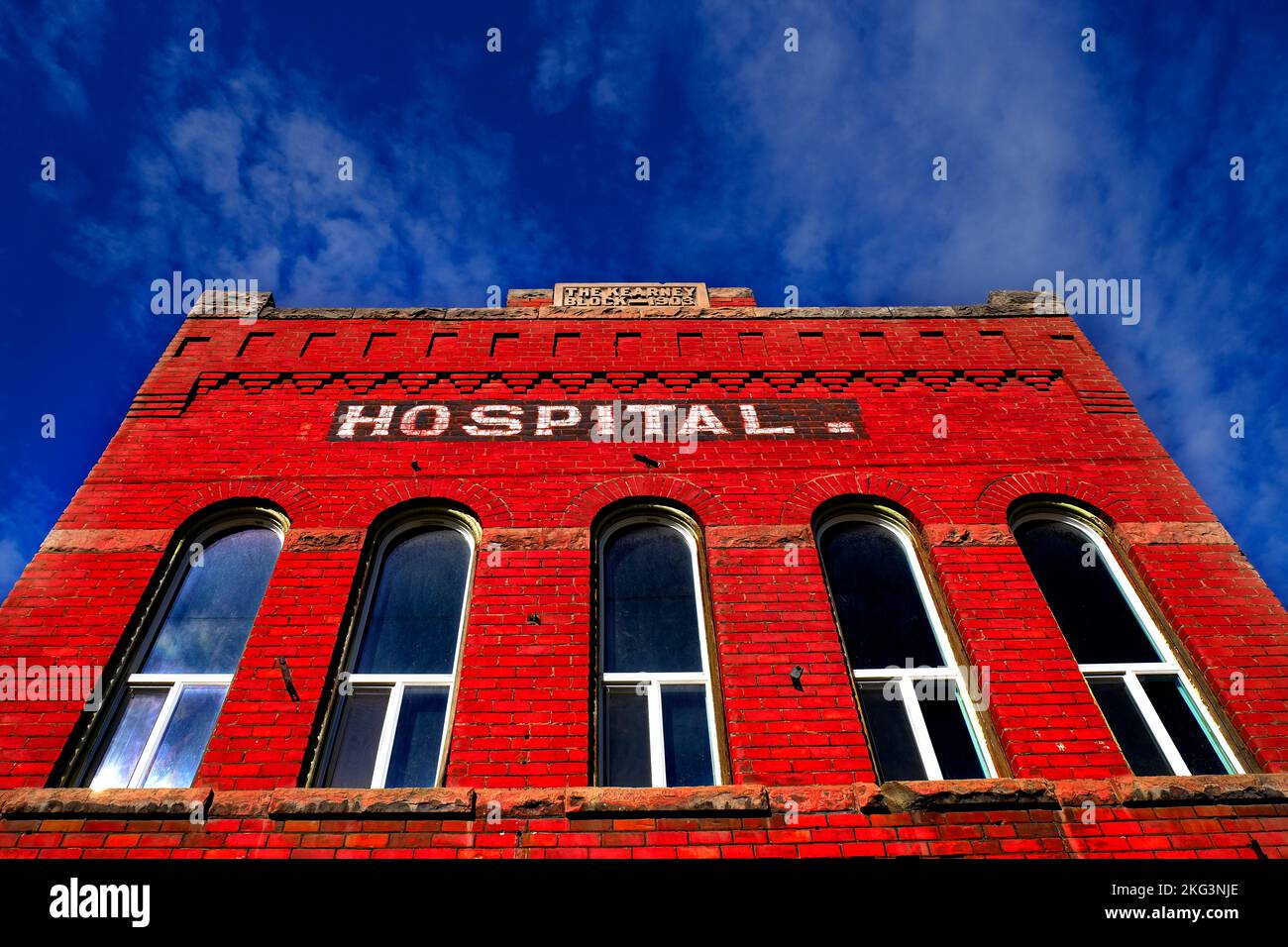 Altes Klinikgebäude aus Ziegelsteinen, alte medizinische Einrichtung mit blauem Himmel und Wolken Stockfoto