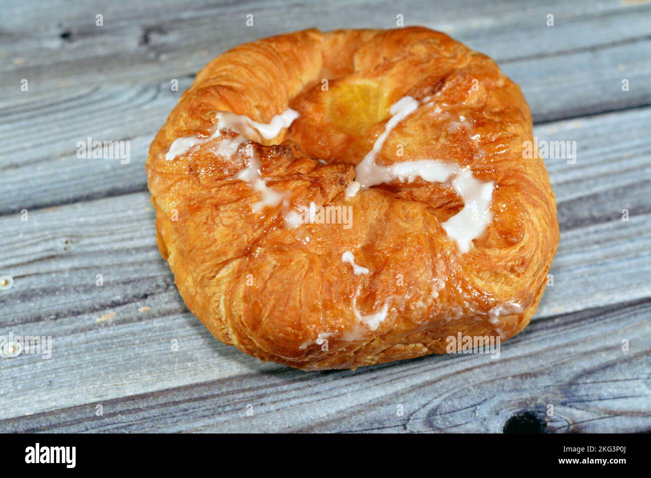 Gebackenes dänisches Gebäck gefüllt und garniert mit Puderzucker und Honig, selektiver Fokus auf süßem Backteig, der im Ofen mit Mehl, Zucker und Gus gebacken wird Stockfoto